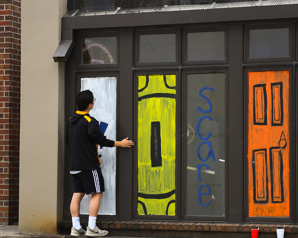 Bryan Wang paints windows with his friends